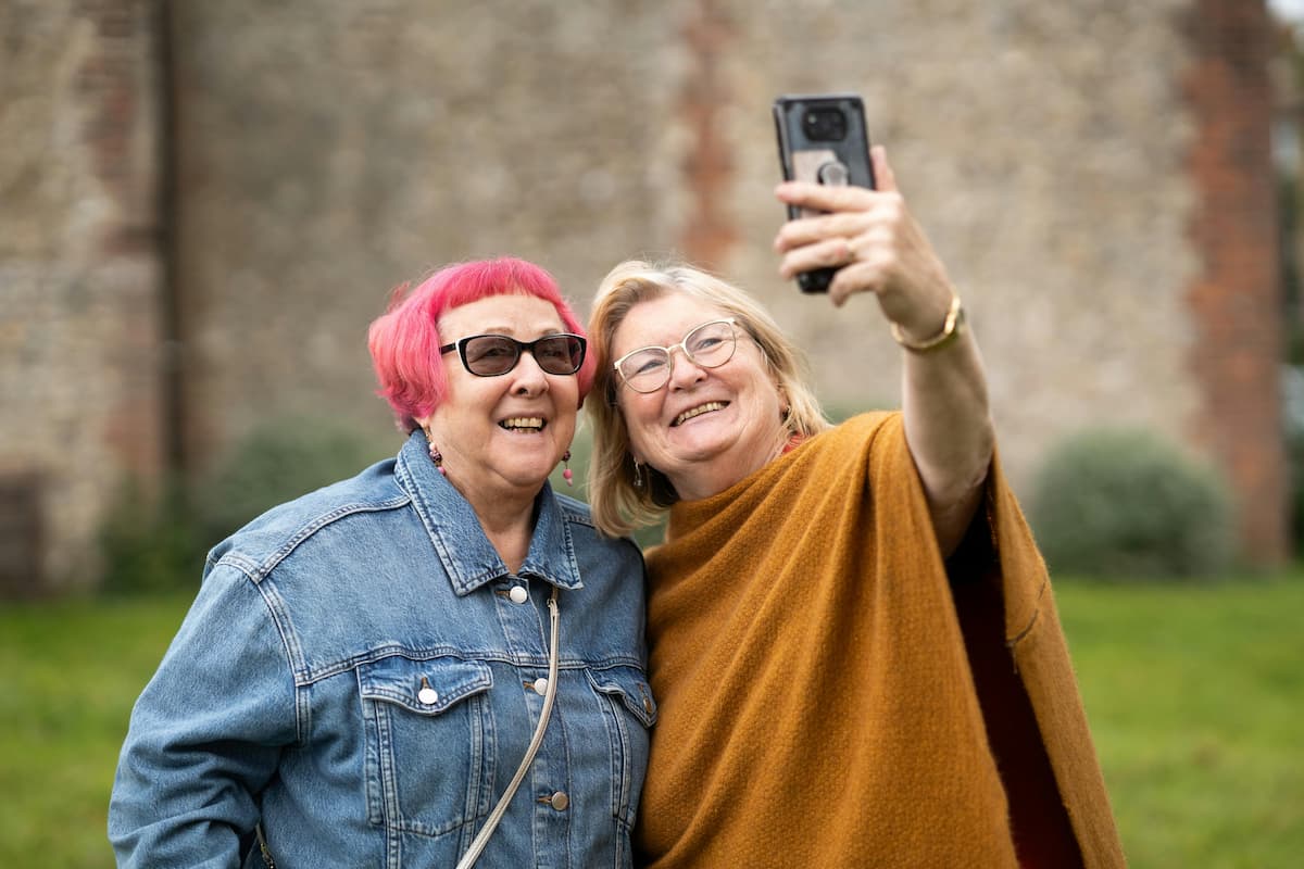 Two older adults smiling and taking a photo together